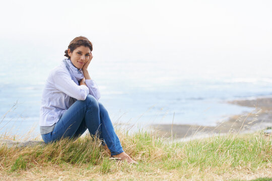 Isnt the view breathtaking. Portrait of a mature woman taking a break from her walk to take in the scenery.