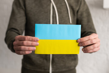 Ukrainian flag in hands. The concept of ending the war in Ukraine.