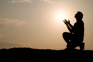 Silhouette of man praying for god's blessing. hope concept