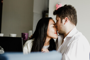 Photo of young couple looking at each other and kissing. Concept of lifestyle, love, friendship, affection and feelings.