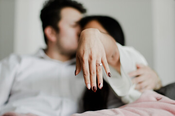 Photo of young couple showing their engagement ring in close-up. Concept of lifestyle, human relations, love.