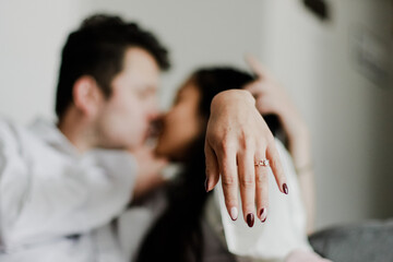 Photo of young couple showing their engagement ring in close-up. Concept of lifestyle, human relations, love.