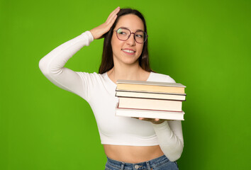 Smiling student girl holding pile of books. Isolated portrait.