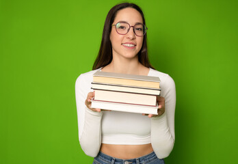 Smiling student girl holding pile of books. Isolated portrait.