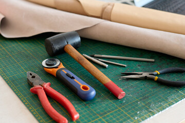 Group of handtools necessary for tanner work and rolled paper for sketching new item models on...