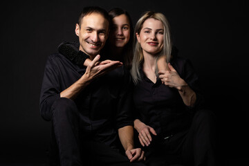 happy family mother, father, daughter on a black background