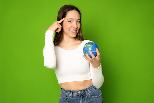 Young Woman Holding Earth Globe Standing Isolated Over Green Background. Eco Concept.