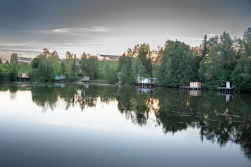 Fototapeta premium Paysage avec lac et maisons en bois de pêcheurs le soir