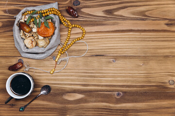 Table top view image of decoration Ramadan Kareem, dates fruit, cup of coffee and almond on wooden background. Flat lay with copy space.