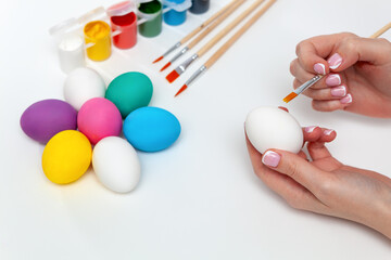 Close-up of a woman's hand holding a complex egg while painting. Happy ether concept