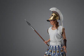 Shot of antique greek fighter woman with golden helmet and spear.