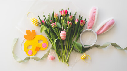 Happy Easter. Stylish dyed easter eggs with spring flowers on white background. Pink tulips with colorful eggs