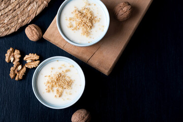Homemade custard with walnut, Turkish dessert muhallebi on a wooden background. Homemade custard with walnut. 