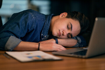 Closeup of young man manager sleeping at workdesk at office