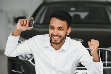 Happy indian man showing the key of his new car