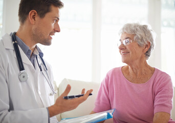 Fototapeta premium Youre in good health. Shot of a male doctor explaining something to his senior patient.
