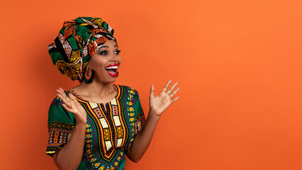 Excited traditional african woman looking at copy space and exclaiming