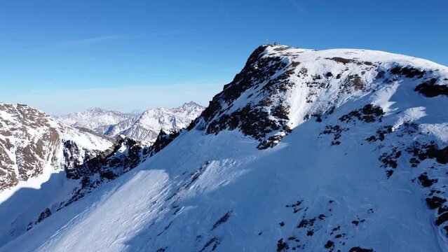 Aerial drone video of forward flight over scenic snowy mountain ridge in winter in the European Alps