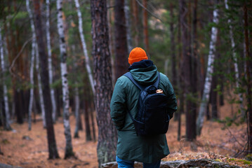 Naklejka premium A tourist enjoys the beautiful scenery in northern Finland. Panorama of the autumn pine forest with formation rocks and faults. Northern nature. Nature of Finland autumn. Tourism northern landscape.