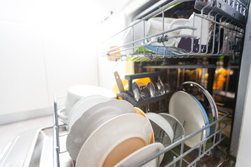 Dishes and cutlery on dishwashing machine. Clean dishes.