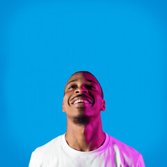Obraz premium Excited young black guy looking up at copy space