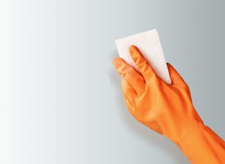 Hand wearing rubber glove on background.