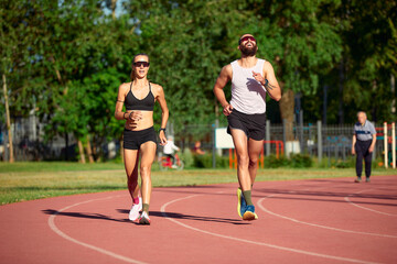 Obraz premium A team of track and field athletes, jointly a man and a woman, train while running.