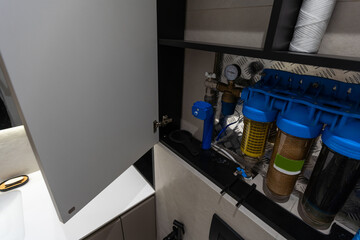 Replaceable cartridges in the water filter system. Water filtration system with replaceable cartridges. A system in the apartment with three tanks for cleaning tap water