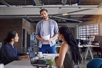 Creative employees at startup, meeting and paper with man team leader and women at desk for web design. SEO, digital marketing and strategy, collaboration and project ideas, discussion with laptop