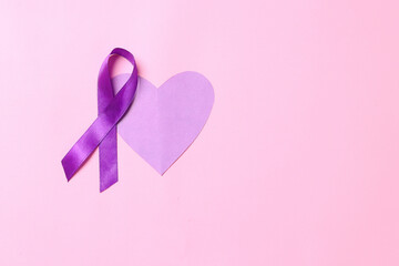Purple ribbon awareness and heart shape on pink background with copy space. World cancer day....