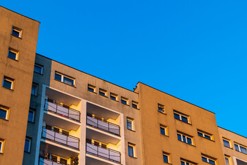 Fototapeta premium Facade with balconies in an apartment block. Multi-family housing, the object against the blue sky.