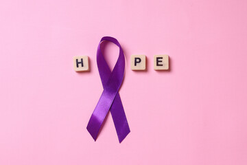 Hope lettering with purple ribbon on pink background. World cancer day. Healthcare and medical concept. Epilepsy day. 