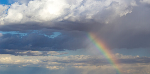 A vibrant rainbow emerges from the clouds 