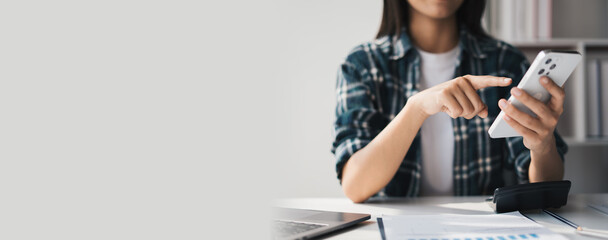 Young asian female student using a smart phone, Creative business woman using smartphone in loft office.