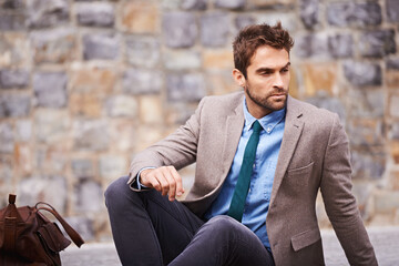 Styled on point. Shot of a handsome and stylish young businessman in an urban setting.