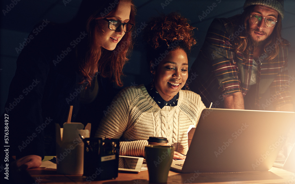 Aufkleber Well succeed together. Shot of a business team using a laptop together on a night shift at work.