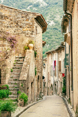 Medieval cobblestone street in the famous Saint Guilhem le Desert village protected by UNESCO, Southern France - 576386104