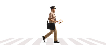 Full length profile shot of a mailman walking on a pedestrian crossing