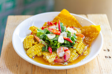 Shrimp and Corn Spicy thai Salad with Fried Wontons White Plate wood table focus view