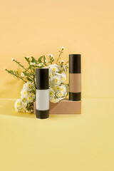 Prebase y base de maquillaje, con fondo color amarillo y flores. Ideal para una marca de cosmética natural