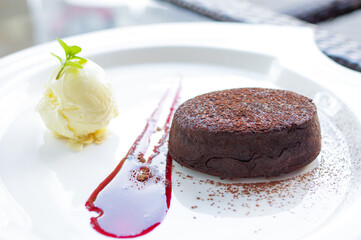 vanilla ice cream and chocolate cake with powder on white plate