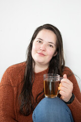 Young woman with wet hair enjoys her cup of tea