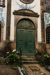 Fototapeta na wymiar Green door and ceramic facade of unknown church, Porto, Portugal,
