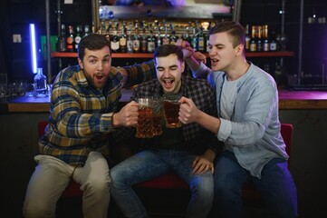 Obraz premium Group of excited friends in beer pub watching sports match