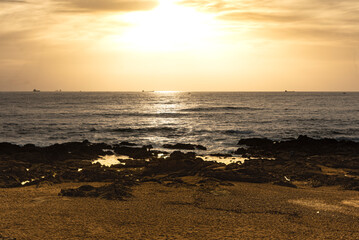 Sun front view, huge golden ball between clouds and sea at sunset beach in Porto - Portugal