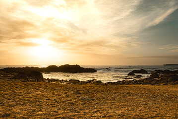 Beautiful golden sunset on a beach with rocks in Porto - Portugal