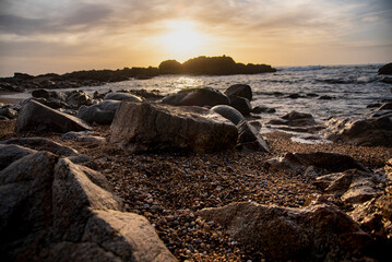 Sun setting behind the rocks at Porto beach - Portugal