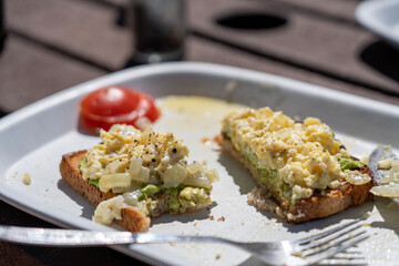 Freshly prepared egg toast with tomato on the side in the morning sunlight