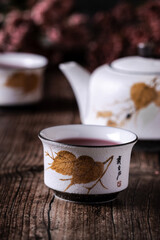 Té Chino de hojas rojas en taza blanca