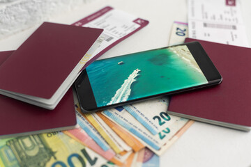 a passport, a flight ticket, differnt currencys on a white surface.